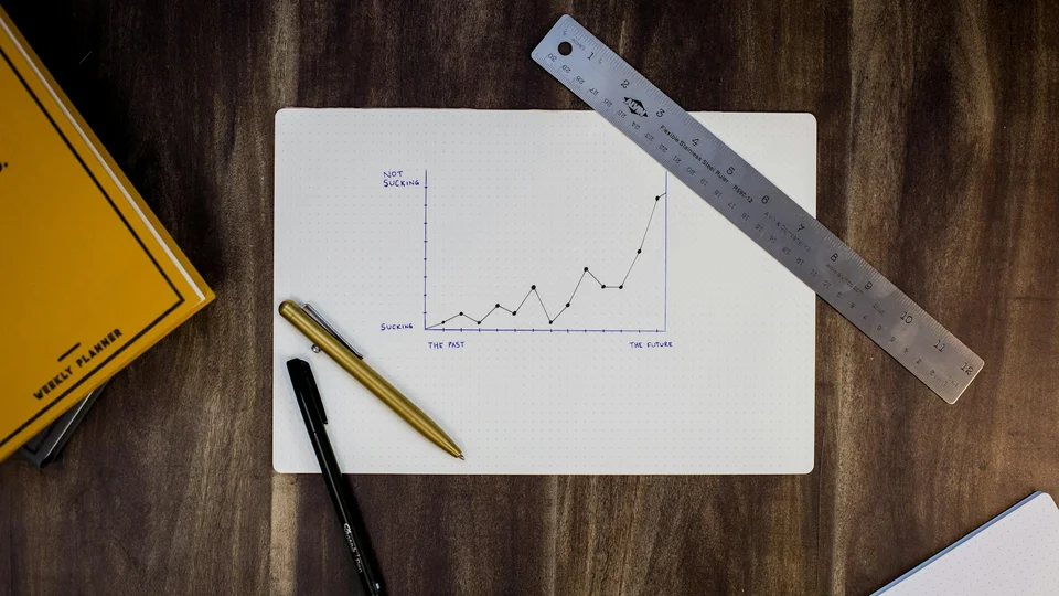Hand-drawn chart on a desk beside a ruler and pens