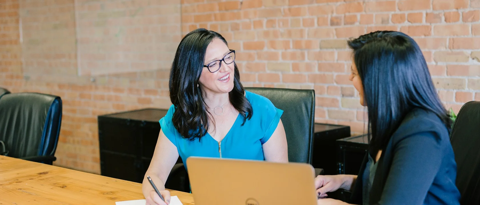 Hiring conversation around a table with laptops and printed role notes