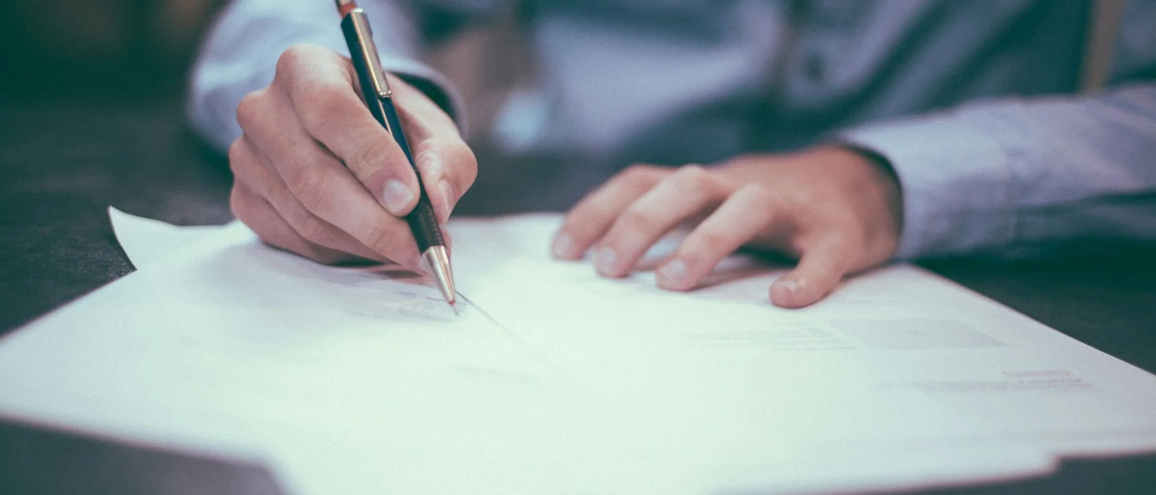 Person writing on a printed form