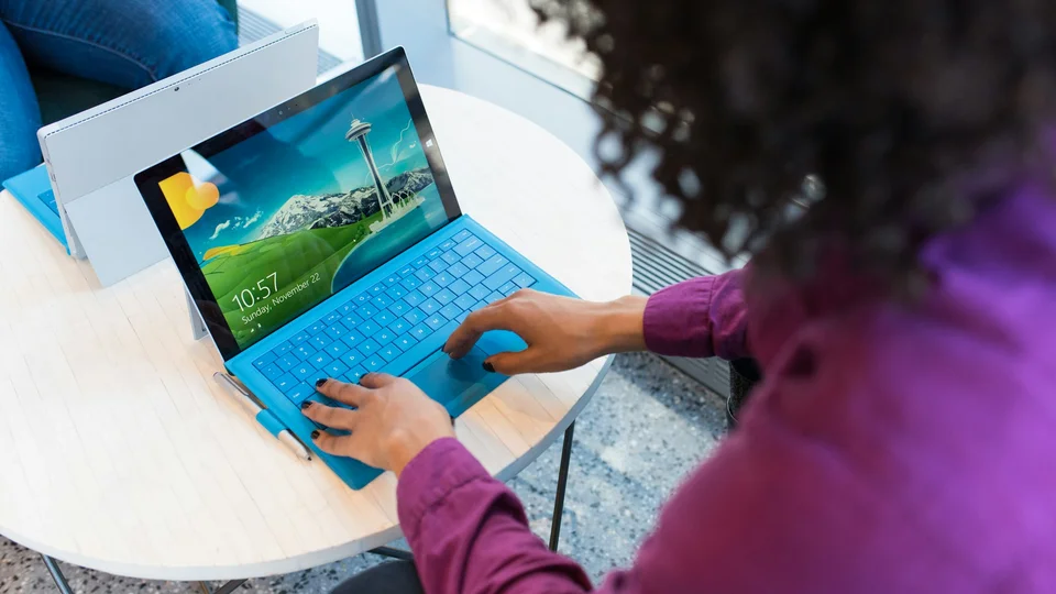 Person working on a laptop at a small table