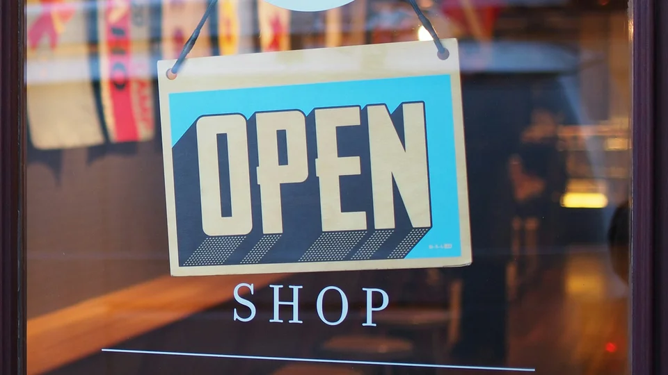 Open sign hanging in a shop window