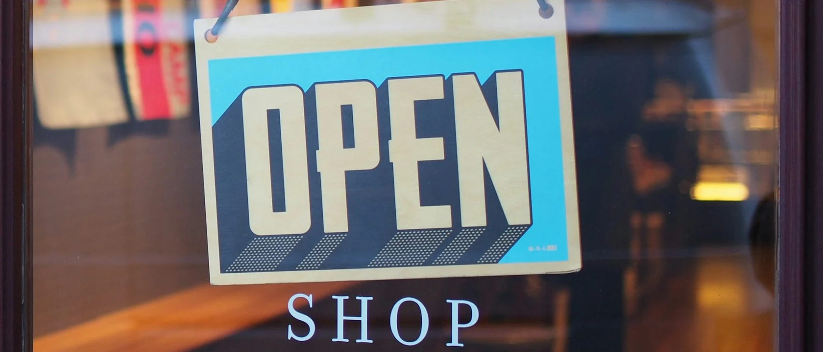 Open sign hanging in a shop window