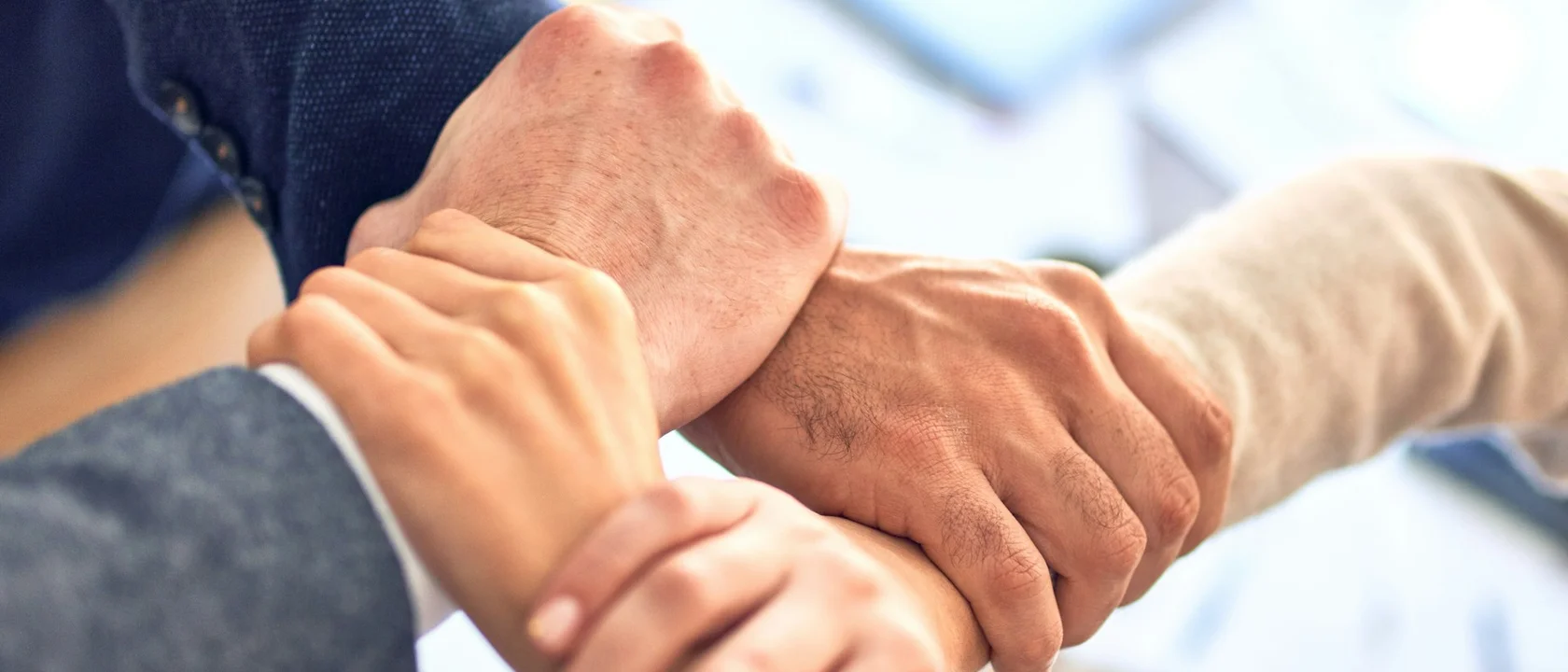 Team members stacking hands over a work table