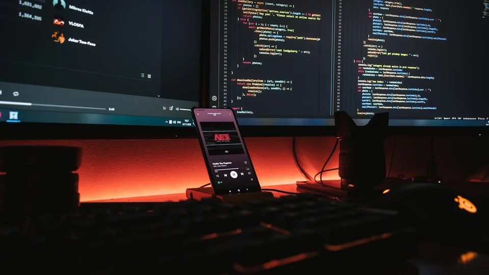 Dual-monitor development desk where a human reviews generated commits