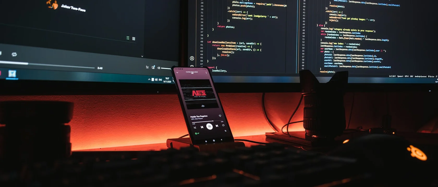 Dual-monitor development desk where a human reviews generated commits